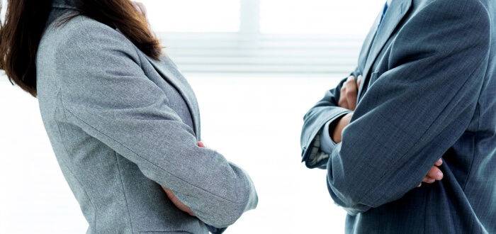 Two people cross their arms and are involved in a dispute