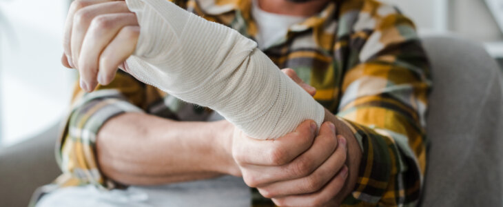 selective focus of injured arm of bearded man in bandage