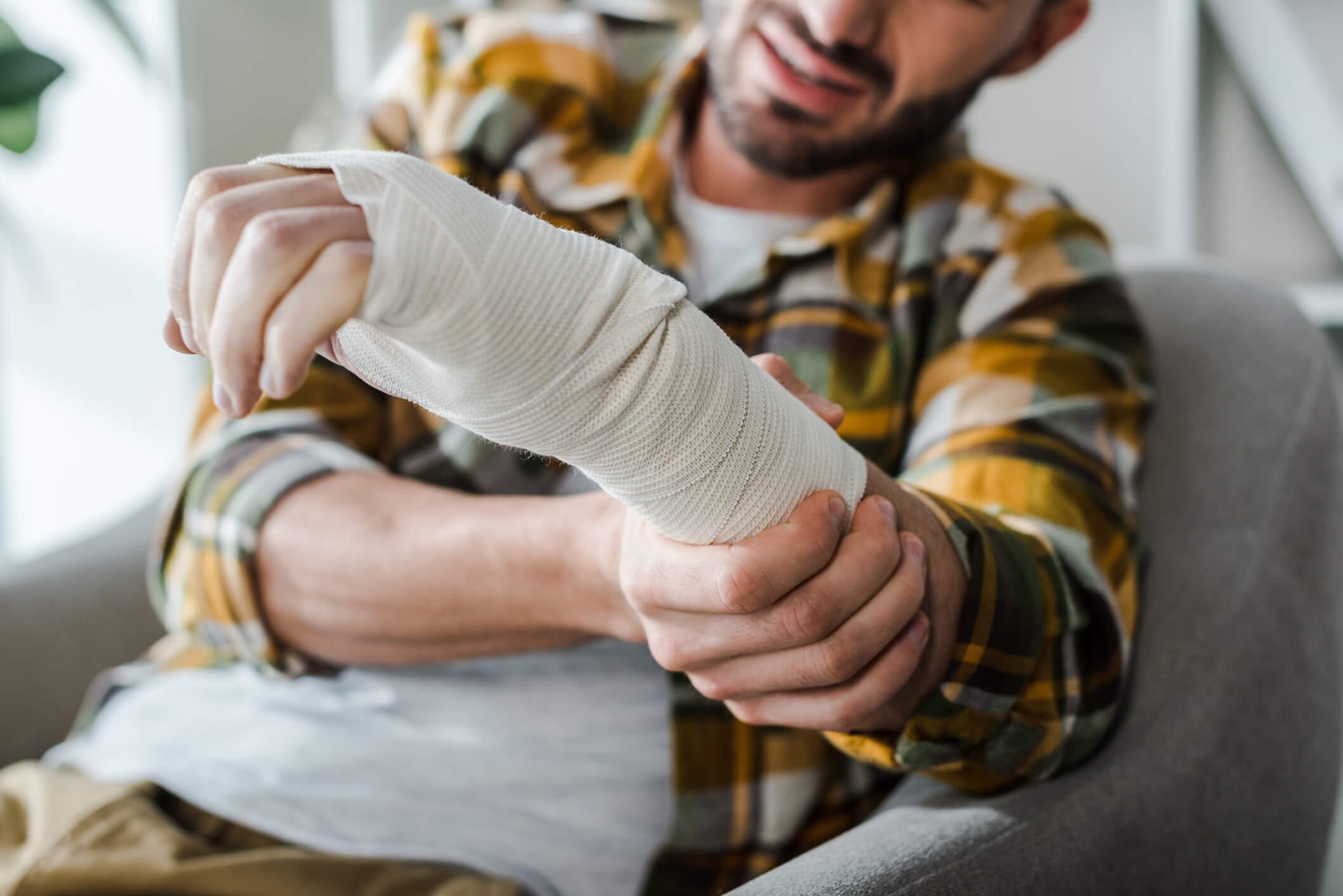 selective focus of injured arm of bearded man in bandage