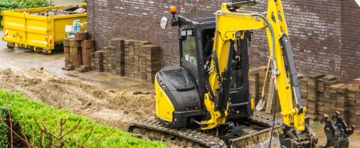 digger machine working on a garden construction in a modern neighborhood